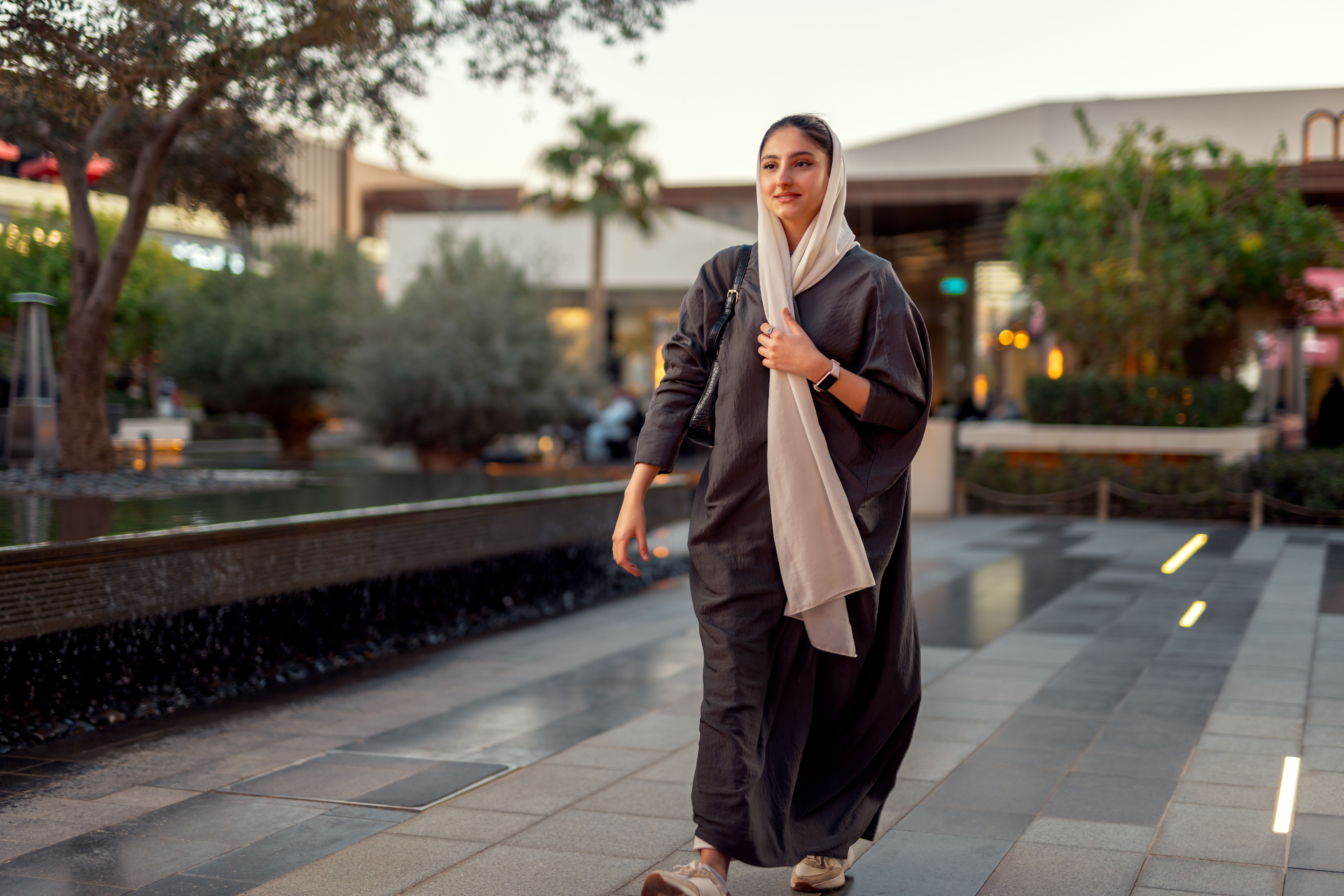 Professional woman walking in a ROSHN Group real estate property